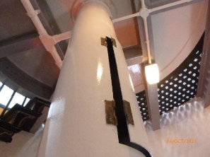 Photograph showing white weight tube fitted to underside of landing. Small curved door of weight tube slightly ajar.