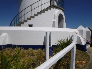 Photograph showing balustrade wall beside lighthouse tower.