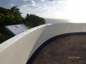 Photograph showing curved white balustrade wall beside interpretative signage. 